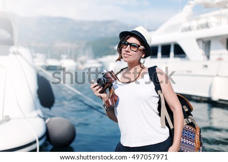Woman with vintage camera at sea harbor