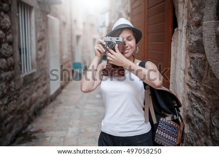Woman traveler with vintage camera taking photo at old town