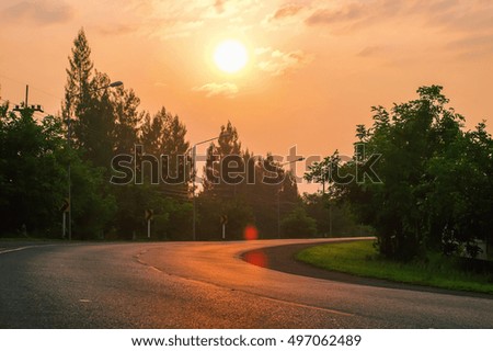a lens flare picture of sunset over road in summer of Thailand.  