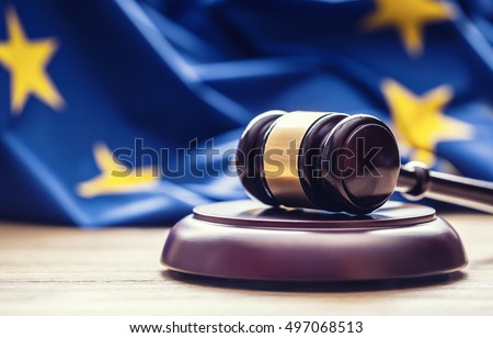 Judges wooden gavel with EU flag in the background. Royalty-Free Stock Photo #497068513