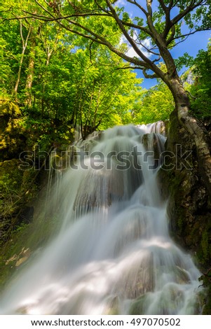 Pristine waterfalls deep in the forest, on a bright sunny day in spring