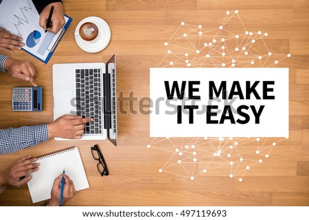 WE MAKE IT EASY Business team hands at work with financial reports and a laptop