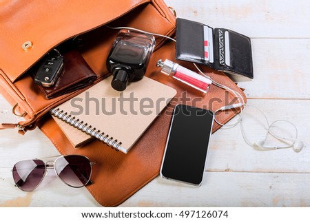 View on women bag stuff on wooden background