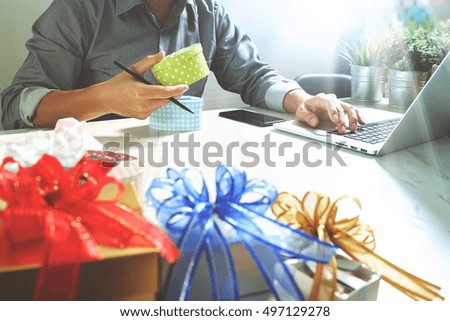 Creative choosing gift with laptop computer and smart phone on mable desk,filter film effect