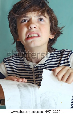 preteen handsome boy in rage about his drawing close up photo