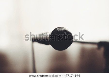 Vocal microphone on stand with blurry background.