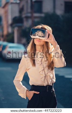 virtual reality headset, virtual reality, VR glasses, augmented reality, VR goggles - happy young girl with virtual reality headset or 3d glasses stay sitting on the street interested by 360 image