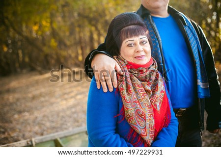 adult couple walking in autumn park. husband and wife walking outdoors in autumn last days