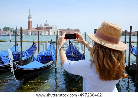 Rear view shot of a female tourist capturing the moments while on Venice at canal.