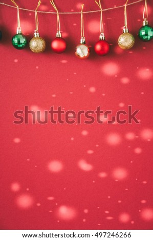 Red and Gold Christmas Balls  hanging on rope on green background. Xmas Decorations. Toned. Selective focus. Copy space.