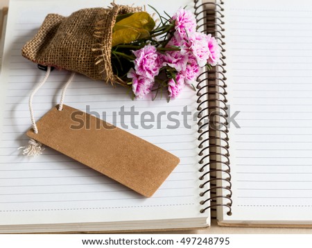 blank tag paper with nature lope and pink flower on note book paper for your text.
