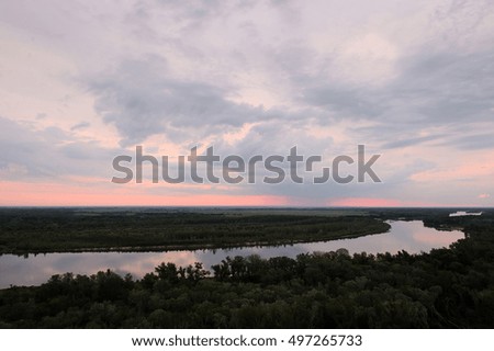 Cold dawn at the river. Summer landscape. Beautiful clouds and hills.