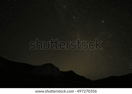 Silhouettes of  mountain peaks and  starry sky.  Milky Way night landscape. Beautiful natural background