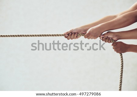 Hands of people pulling tug of war Royalty-Free Stock Photo #497279086