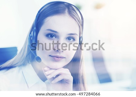 Young businesswoman in headphones with microphone, head to chin. Office at background. Concept of call center.  Toned image