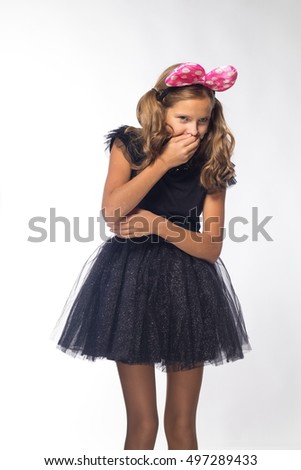 emotional girl actress cheerful blonde in a black dress with a pink bow on a white background