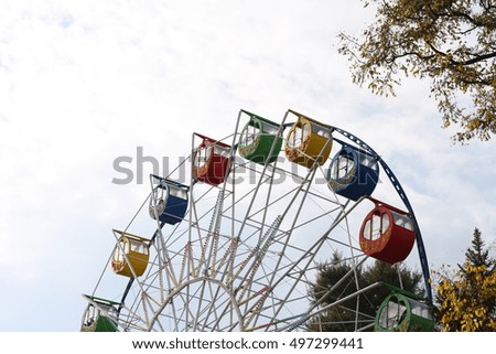 Colored Booths of Ferris wheel at an autumn park.