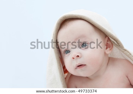 Portrait of a baby in a hooded white bathrobe.
