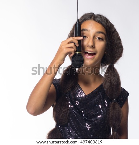 young brunette girl with long hair in black dress with microphone on a white background