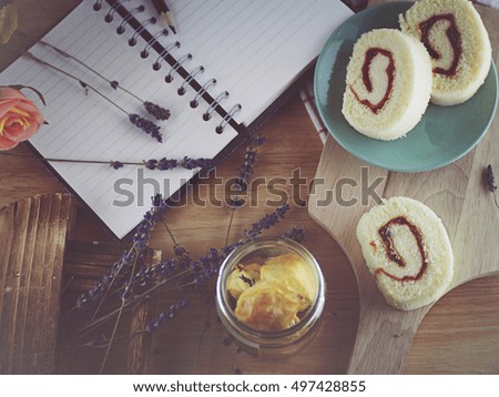Notebook and pencil with cupcake on rustic table from above, cozy and sweet breakfast, good morning or have a nice day concept
