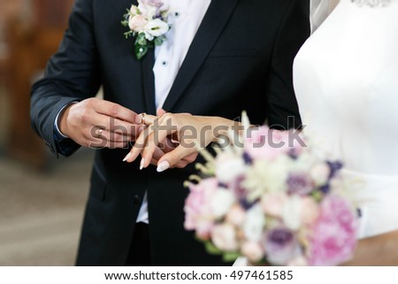 bride and groom wearing rings on the wedding ceremony