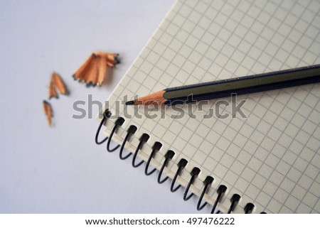 Blank notebook with pencil and pencil shavings on white background 