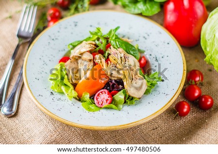 Fresh vegetables and artichokes - a healthy and tasty food. Vegetarian dish, pepper, tomatoes, lettuce closeup on the kitchen table. Royalty-Free Stock Photo #497480506