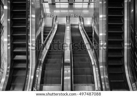 Four parallel automatic escalators in business building.