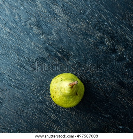 Green pear on a dark background