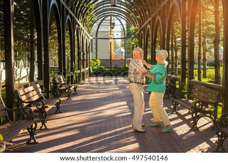 Senior couple dancing. Elderly people are smiling. Waltz in the park. Choose an active lifestyle.