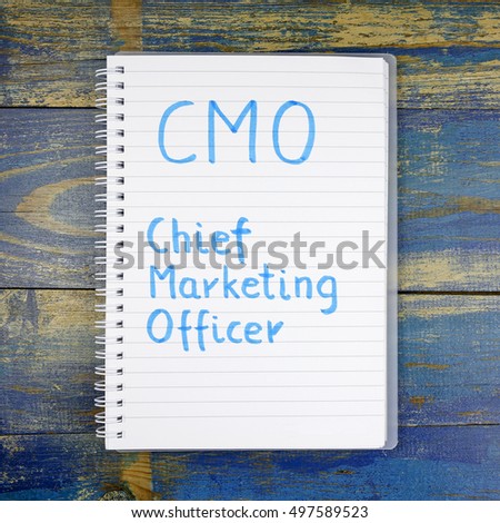 CMO- Chief Marketing Officer written in notebook on wooden background