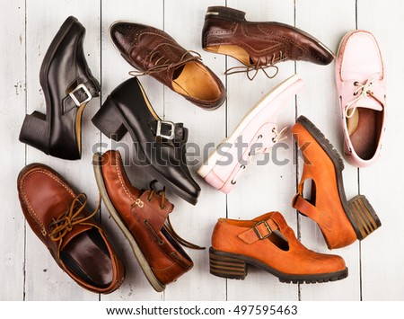 Set of different unisex shoes on white wooden background Royalty-Free Stock Photo #497595463