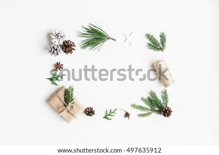 Christmas composition. Christmas gift, pine cones, fir tree branches on white background. Top view, flat lay, copy space.