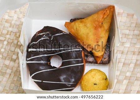 lunch/snack box with sweets/Mithai for diwali, Indian junk food like chocolate doughnut, laddu, cake, Fried Potato Samosa popular in India