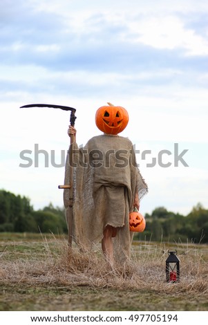 scarecrow pumpkin head in a field