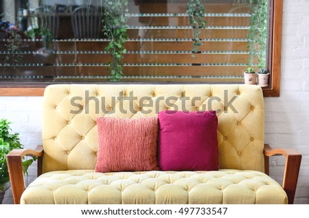 two pillow on yellow sofa couch 