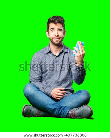 man sitting on the floor looking a mobile surprised