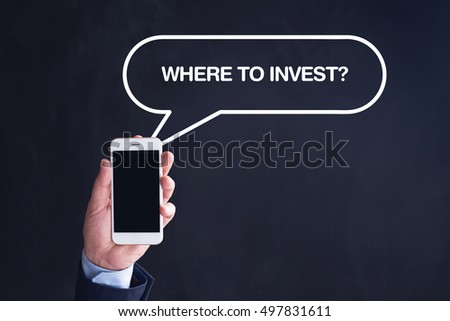 Hand Holding Smartphone with WHERE TO INVEST? written speech bubble