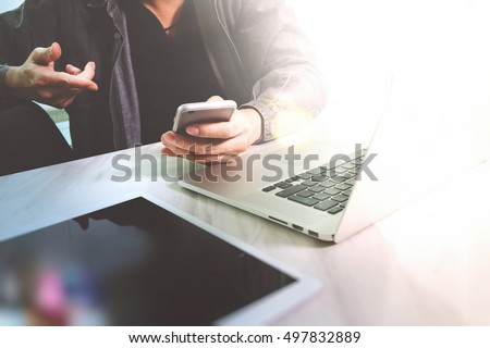 business man hand working on laptop computer and digital tablet and smart phone on marble desk, sun flare effect