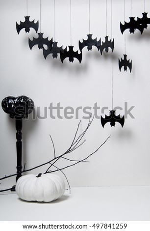 halloween with black silhouettes of bats and pumpkins with a branch of a tree on a white background