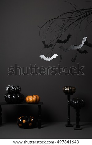 halloween with black bats on a tree and painted pumpkins on a dark background