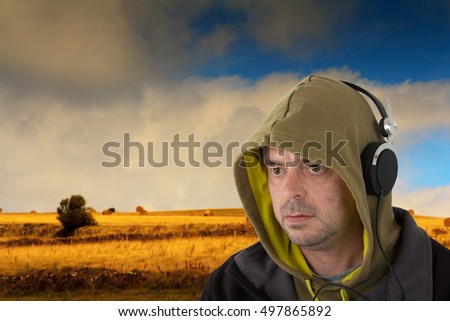 Man in hoodie listening to music on headphones