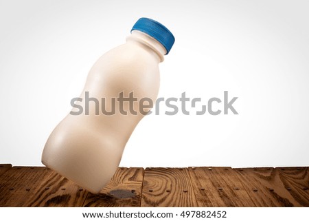 A small bottle of milk on wooden background