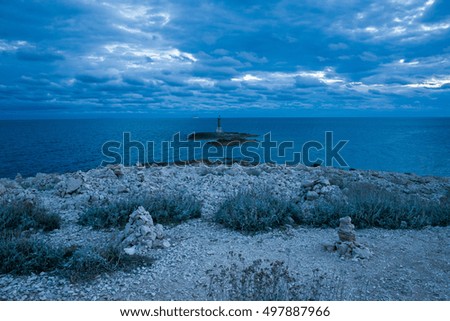 Lighthouse Razanj Croatia. Beautiful nature and landscape photo of Adriatic Sea in Dalmatia. Nice summer evening at dusk. Blue cool tones in water and cloudy sky. Calm, peaceful outdoors picture. 