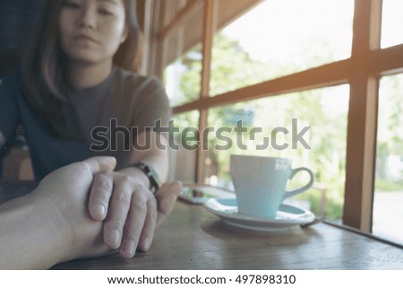 Asian girlfriend and boyfriend holding each other hand with unhappy face