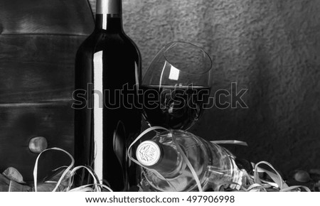 Still life with red wine and heart on a barrel. Black - white.