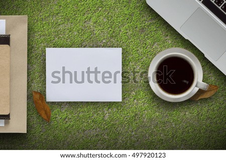 Coffee cup,laptop and paper note in green background.Top view with copy space.