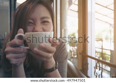 Closeup image of Asian woman drinking hot coffee with feeling happy in cafe , good lifestyle