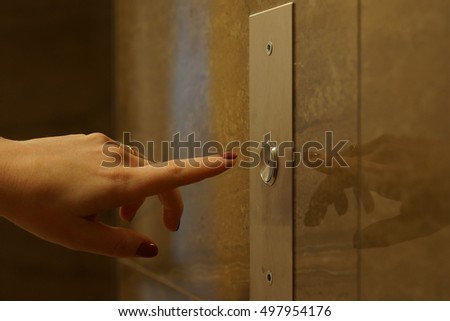 Woman about to push the elevator button. finger presses the elevator button. businessman elevator. hand reaches for the button of the elevator call.