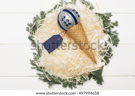 Colorful Christmas or New Year decoration with silver blue ball, tag, ice cream cone, tree branch on vintage white background